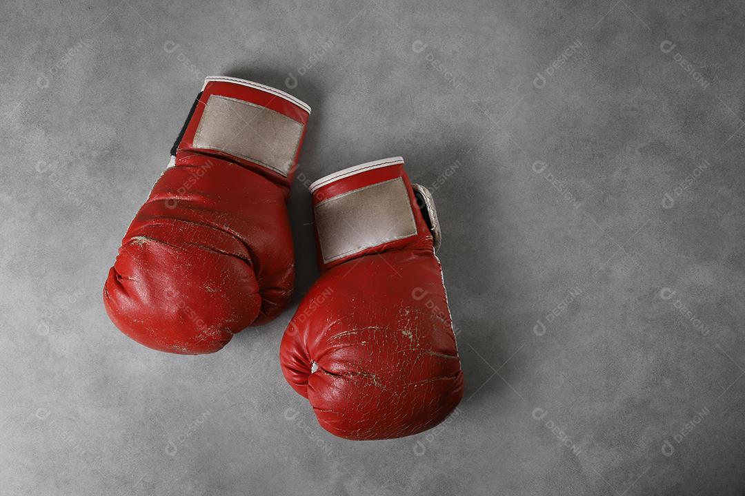 Boxing gloves on the gym floor after training. Gray grunge concrete background.