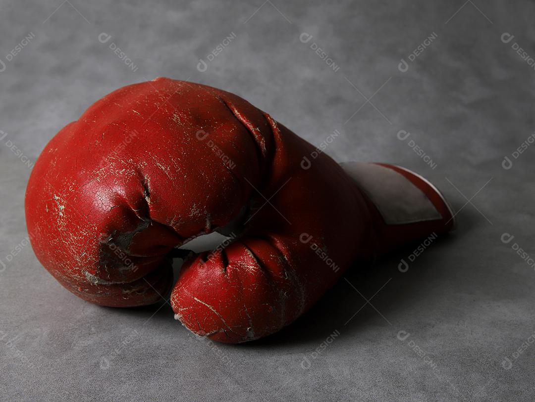 Luvas de boxe no chão do ginásio após o treino. Fundo de concreto cinza grunge.