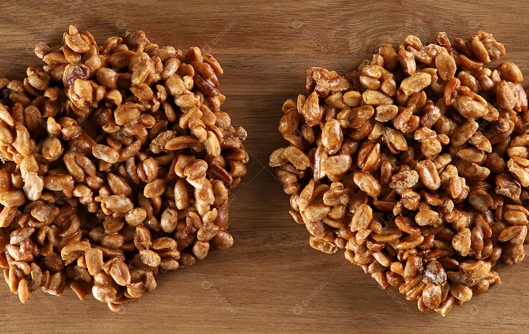 Pé de Menino ou Pé de Moleque é um doce de amendoim típico da Festa Junina. Comida tradicional brasileira, doce festa junina. Fundo Madeira Rústica Arraial