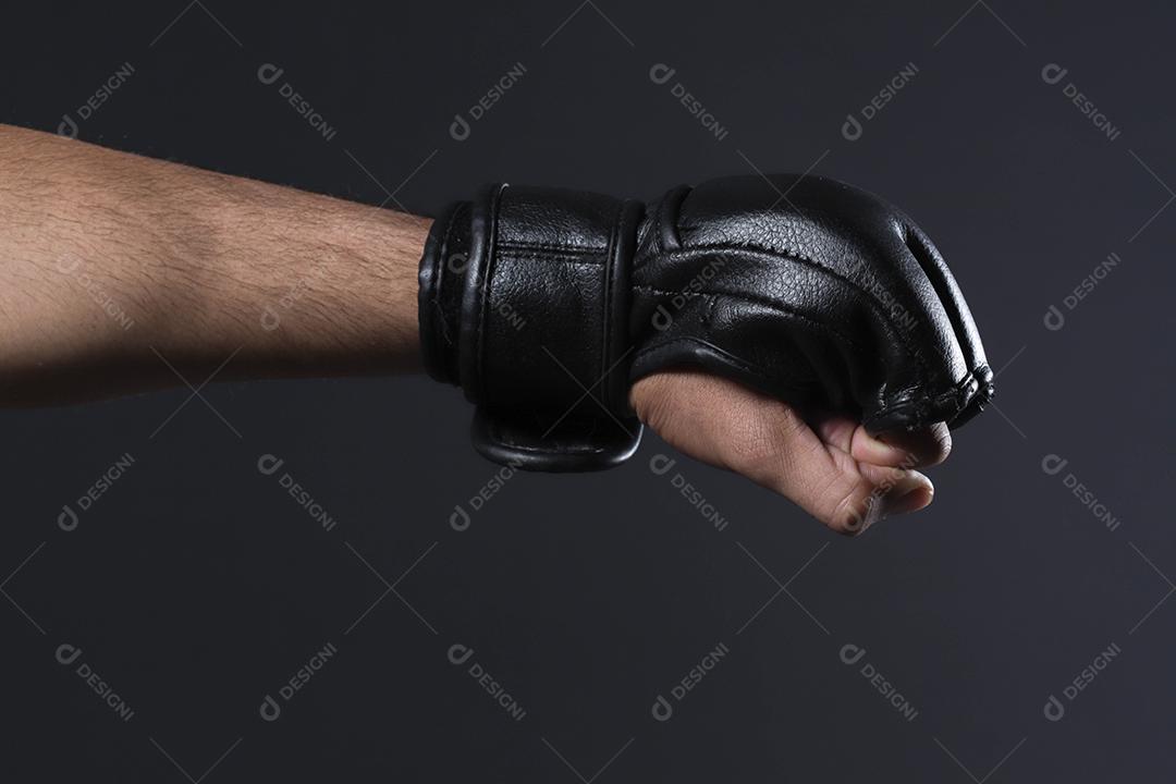 Feche a mão do lutador masculino com luvas de MMA. Lutador cerrou o punho antes de uma luta ou treinamento em uma academia de esportes