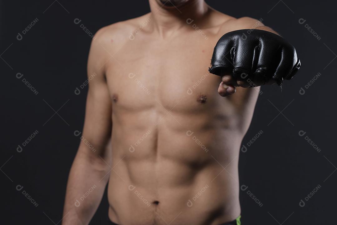 Feche a mão do lutador masculino com luvas de MMA. Lutador cerrou o punho antes de uma luta ou treinamento em uma academia de esportes