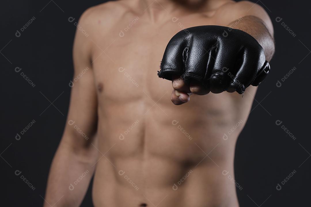Feche a mão do lutador masculino com luvas de MMA. Lutador cerrou o punho antes de uma luta ou treinamento em uma academia de esportes
