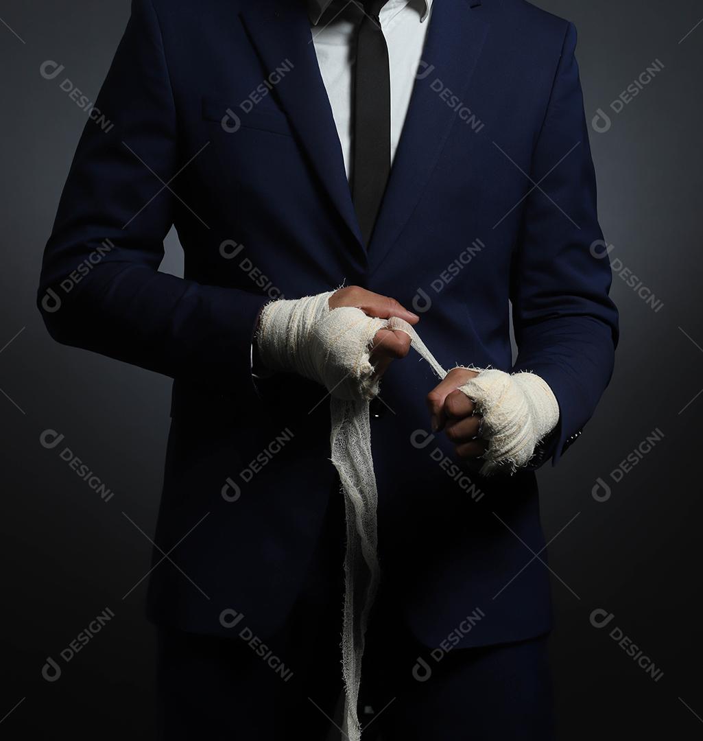 Mão masculina fechada de lutador de empresário de terno com bandagens e punhos cerrados