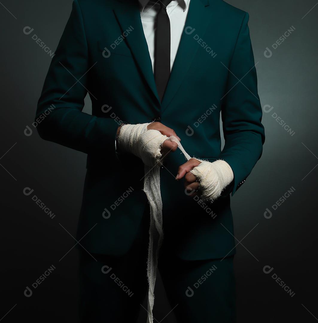 Closed male hand of businessman fighter in suit with bandages and clenched fists