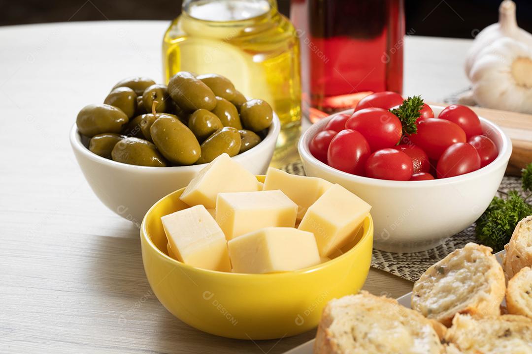 Frascos de aperitivo com queijo, azeitonas e tomate cereja.
