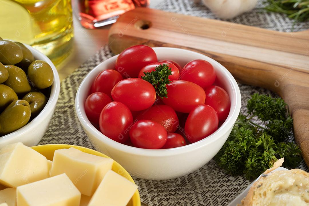Frascos de aperitivo com queijo, azeitonas e tomate cereja.
