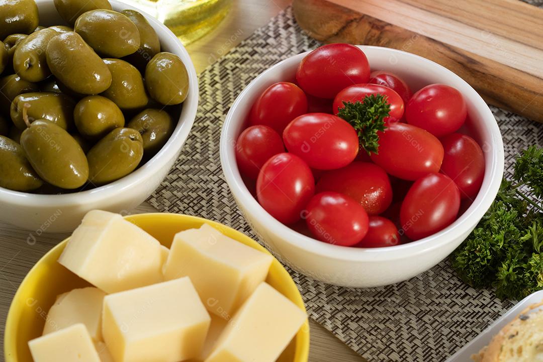 Frascos de aperitivo com queijo, azeitonas e tomate cereja.