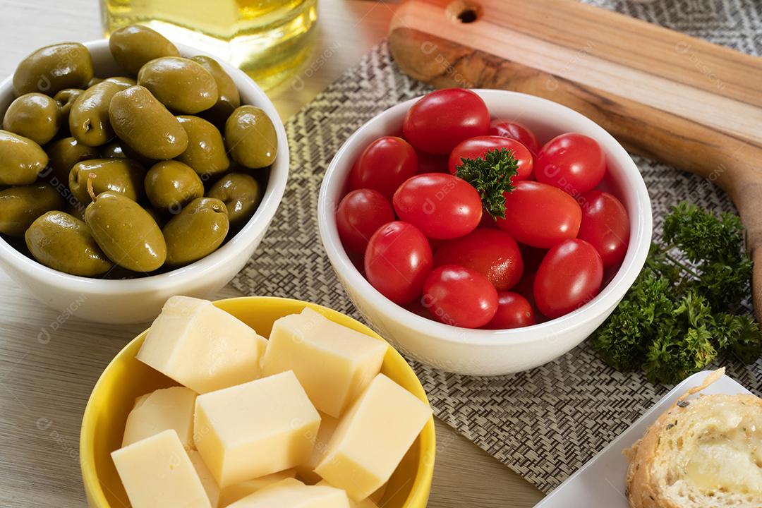 Frascos de aperitivo com queijo, azeitonas e tomate cereja.