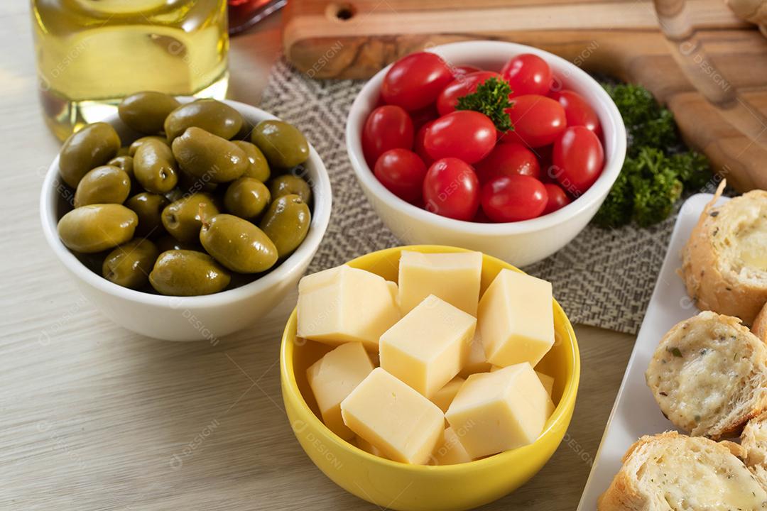 Frascos de aperitivo com queijo, azeitonas e tomate cereja.