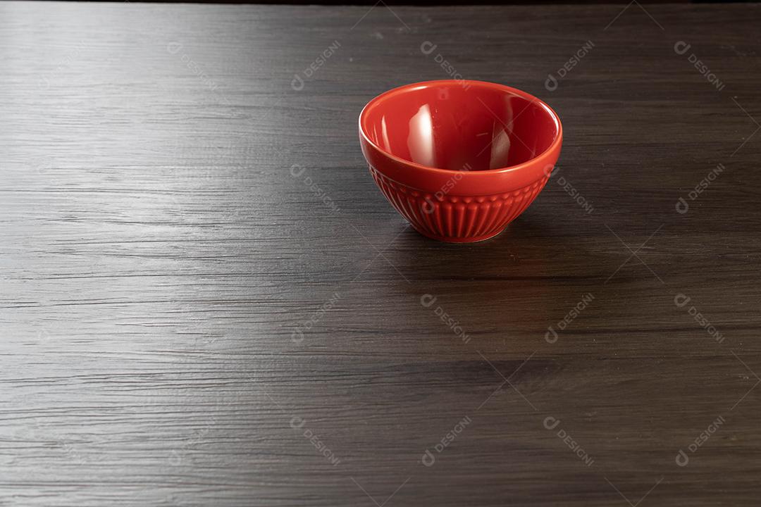 Tigela vermelha em fundo de madeira