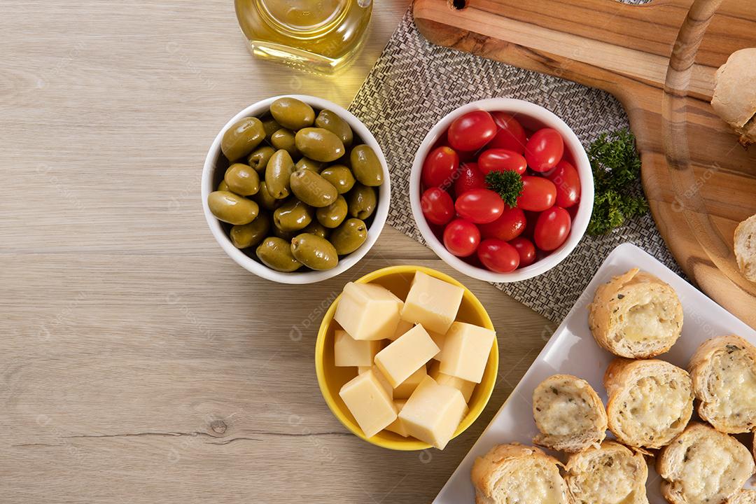 Frascos de aperitivo com queijo, azeitonas e tomate cereja.