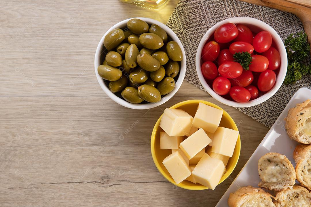 Frascos de aperitivo com queijo, azeitonas e tomate cereja.