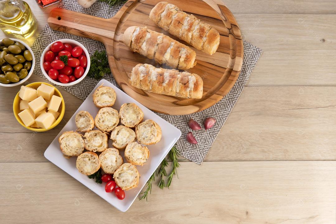 Pão de alho em prato quadrado branco em cima da mesa com queijo, ros