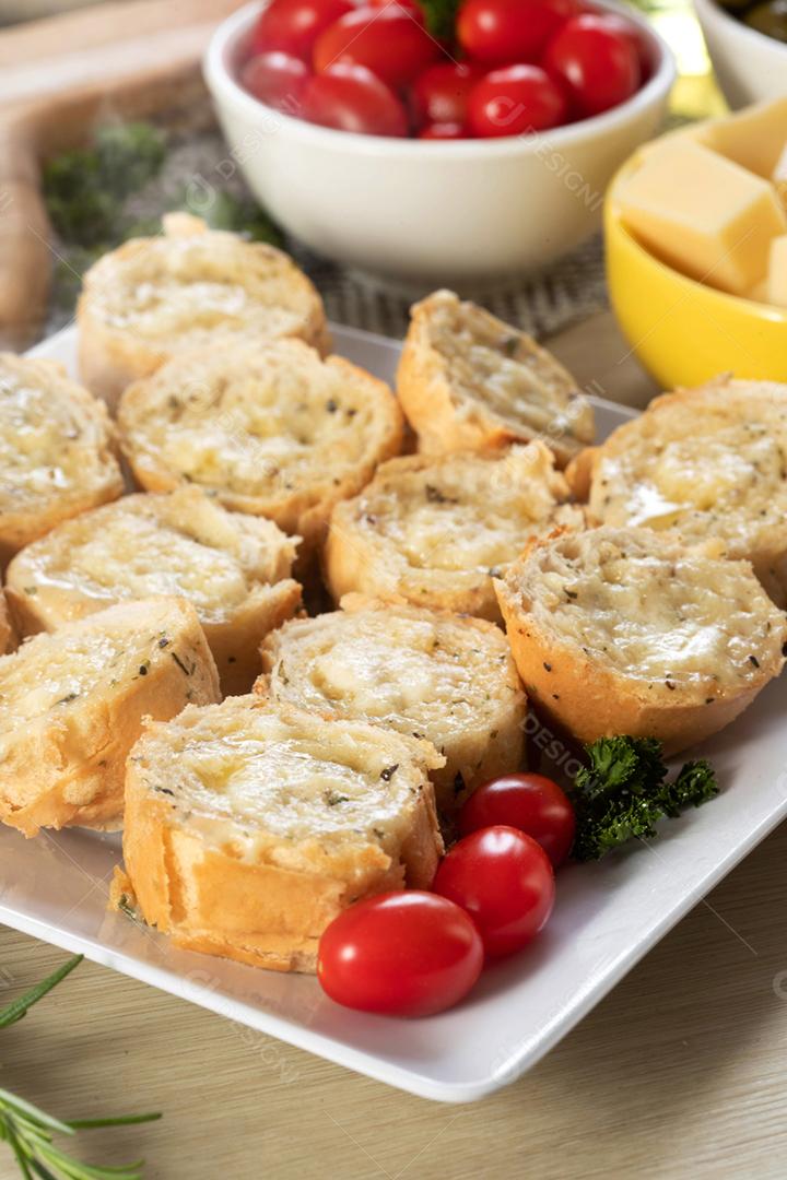 Pão de alho em prato quadrado branco em cima da mesa com queijo, ros