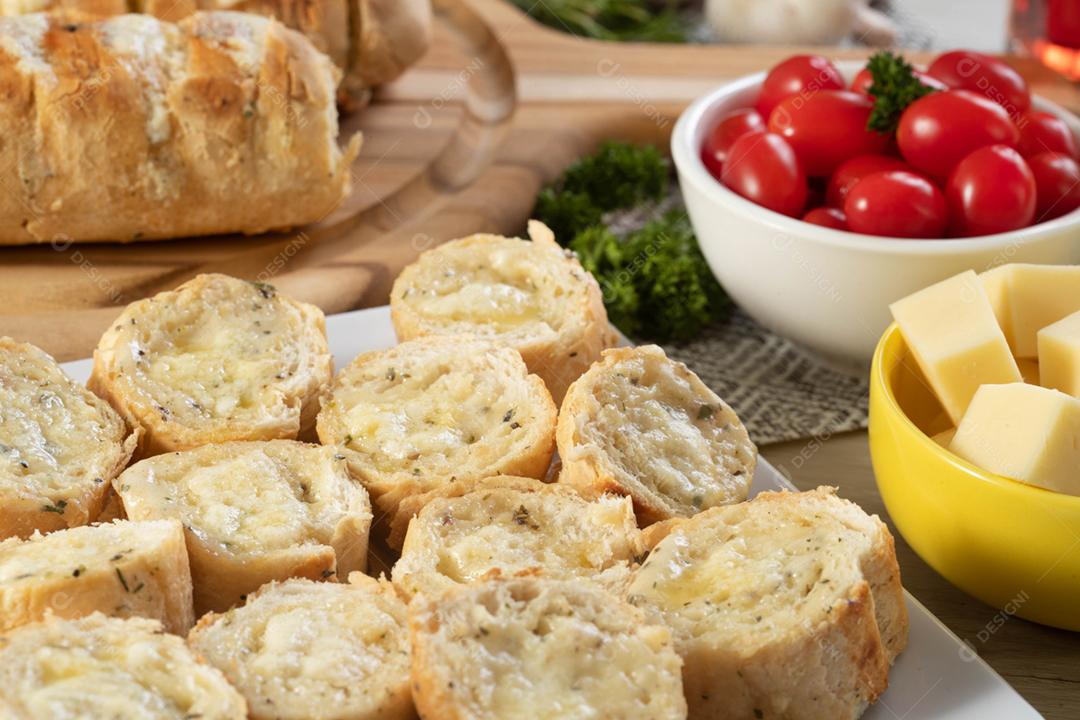 Pão de alho em prato quadrado branco em cima da mesa com queijo, ros