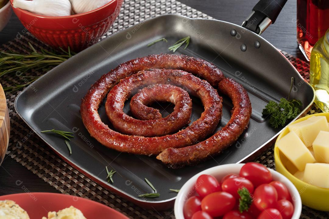 Linguiça em um prato vermelho na mesa de churrasco wi
