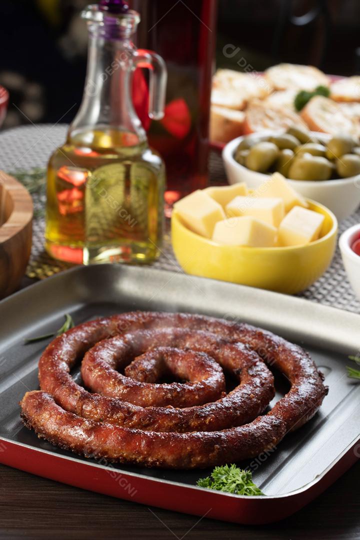 Linguiça assada com pão de salsicha e alho em um prato vermelho na mesa de churrasco wi