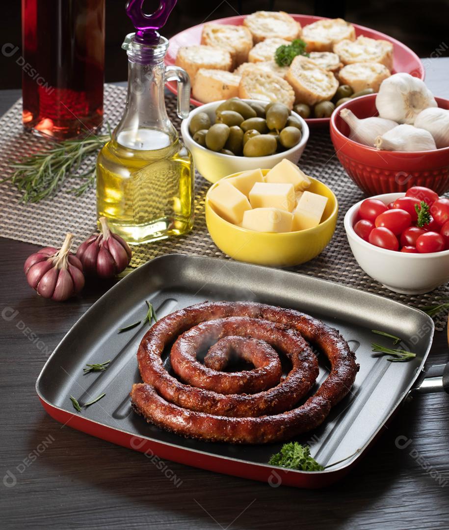Linguiça assada com pão de salsicha e alho em um prato vermelho na mesa de churrasco wi