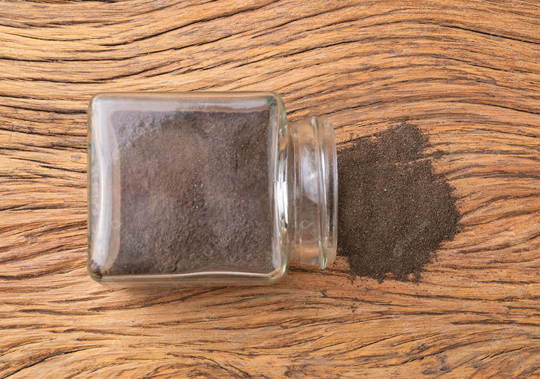 Vista superior, pimenta preta moída em uma panela de vidro.