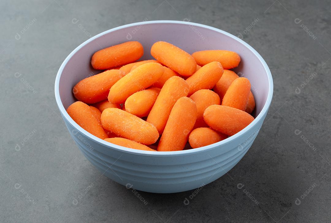 Cenouras em uma tigela sobre fundo de pedra.