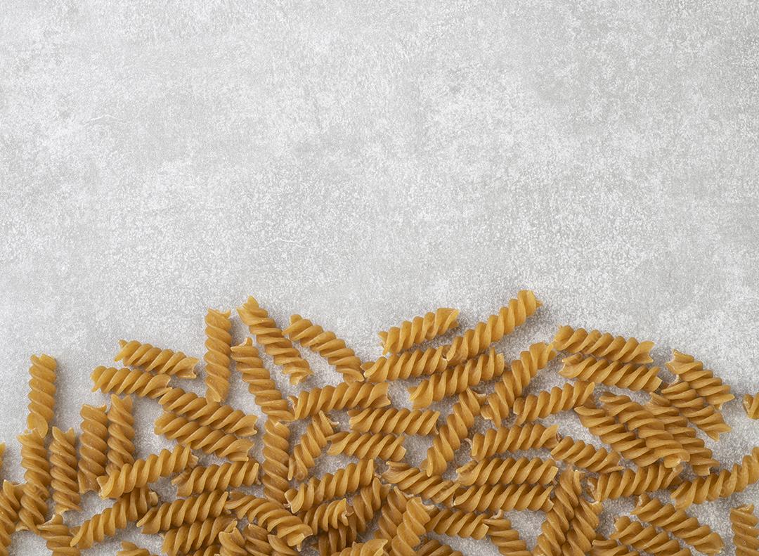 Macarrão fusilli de trigo integral sobre bancada de concreto