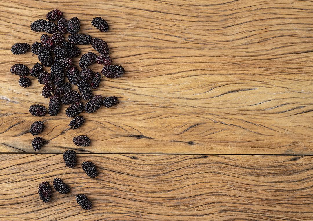 Um grupo de amoras sobre a mesa de madeira