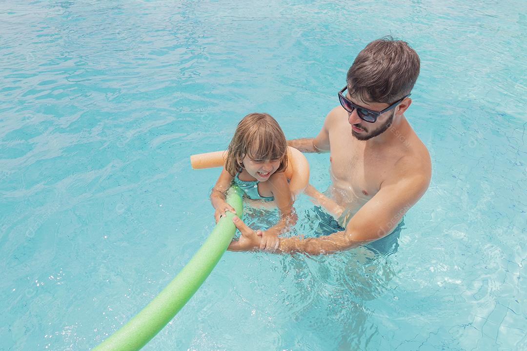 Pai e filha se divertindo nas férias de verão à beira da piscina