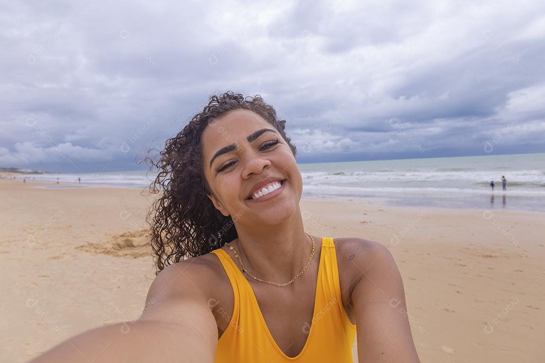 Mulher Linda Jovem afro tomando uma selfie na praia