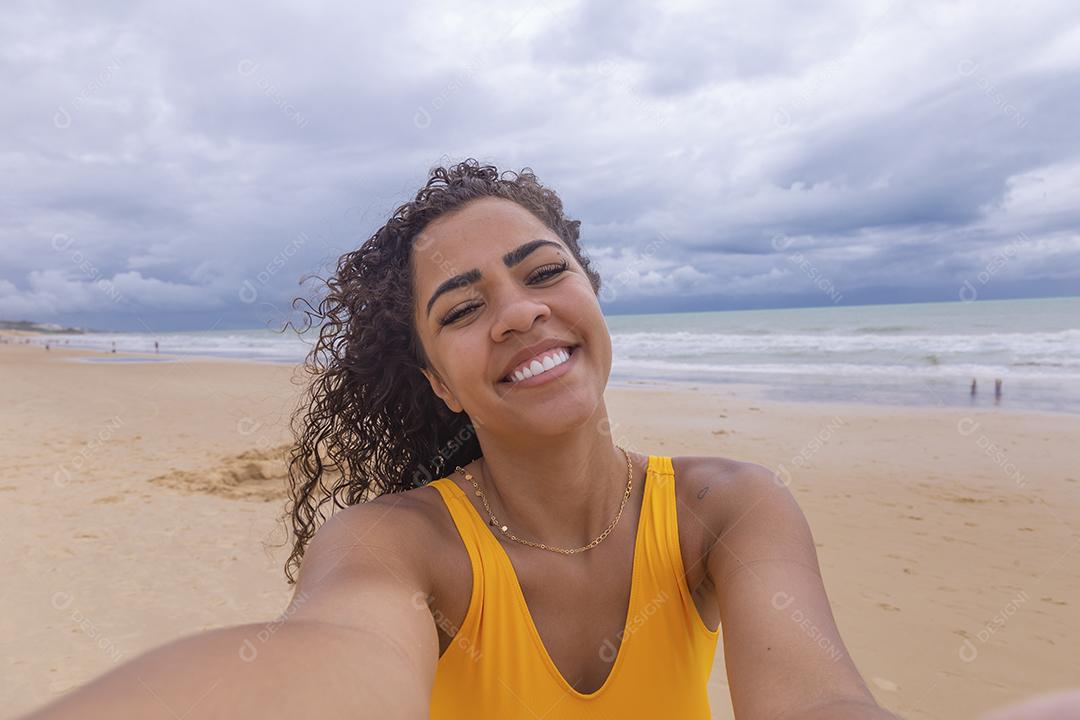 Mulher Linda Jovem afro tomando uma selfie na praia