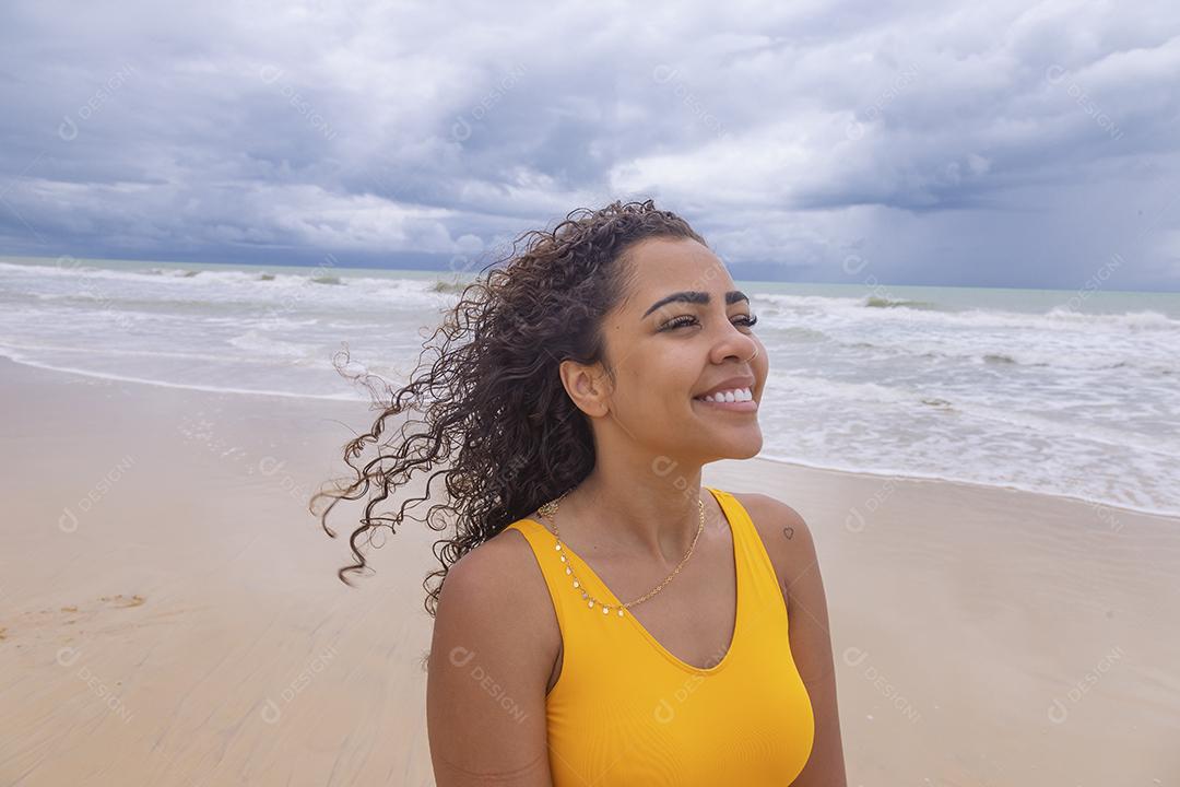 Morena jovem bonita, cabelo encaracolado, biquíni, praia. Férias de férias de verão afro-americanas.