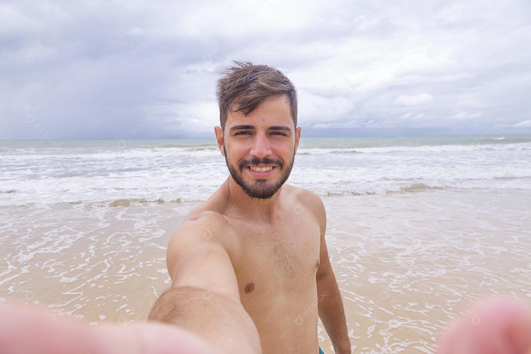 Menino tirando uma selfie na praia