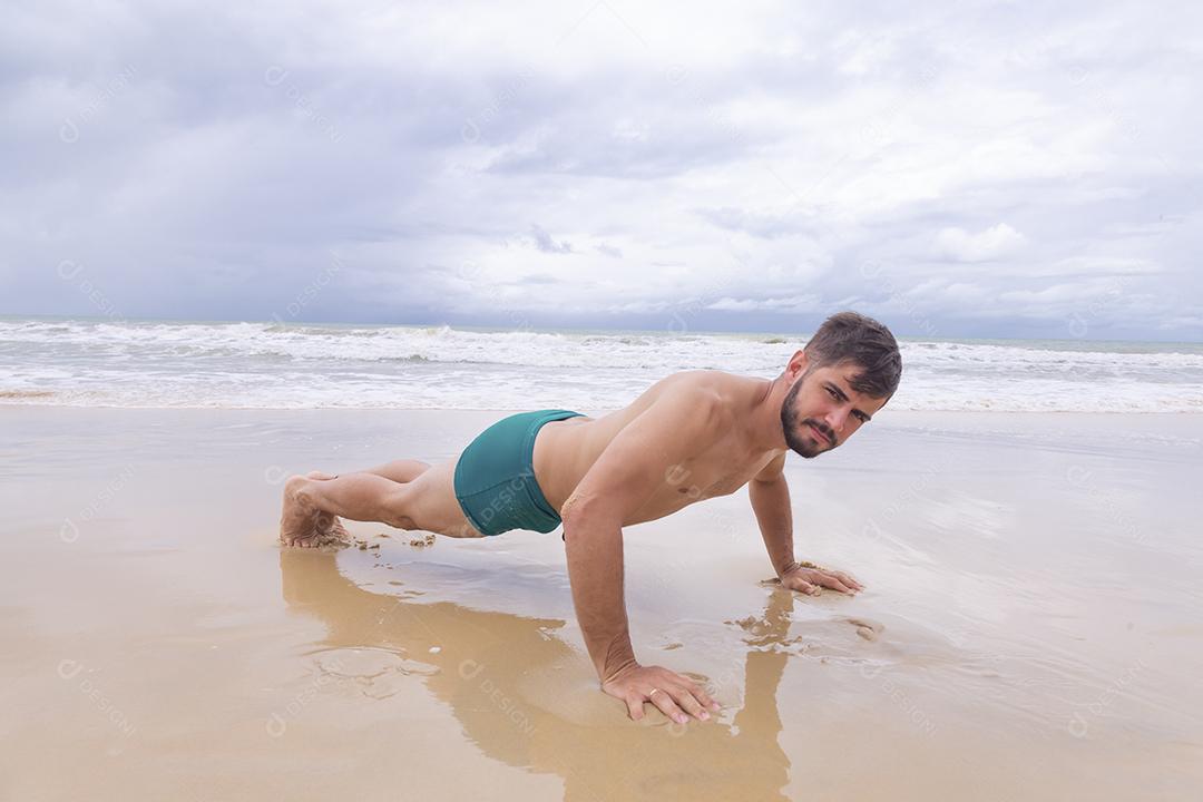 Exercício de treino homem ativo bonito saudável com corpo musculoso apto fazendo exercícios