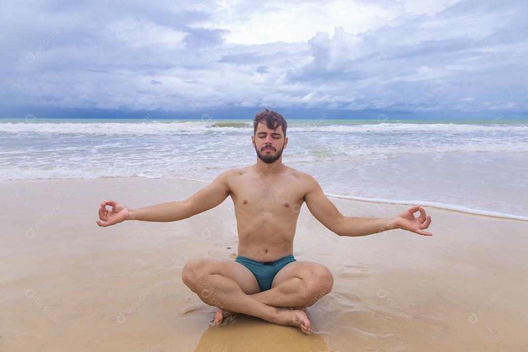 Menino meditando na praia