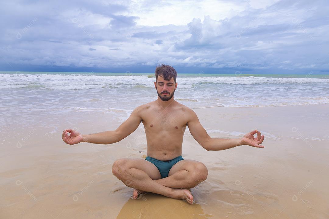 Menino meditando na praia