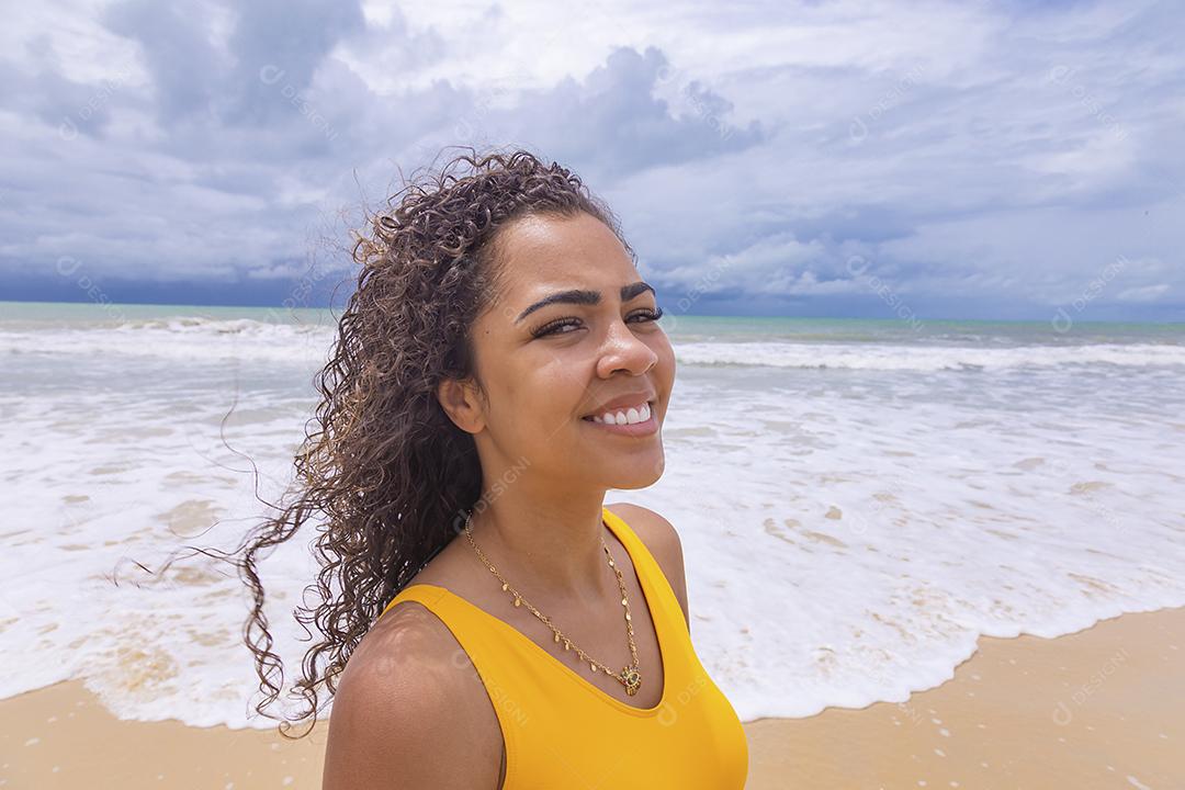 Afro morena jovem bonita, cabelo encaracolado, biquíni, praia. Férias de férias de verão afro-americanas.