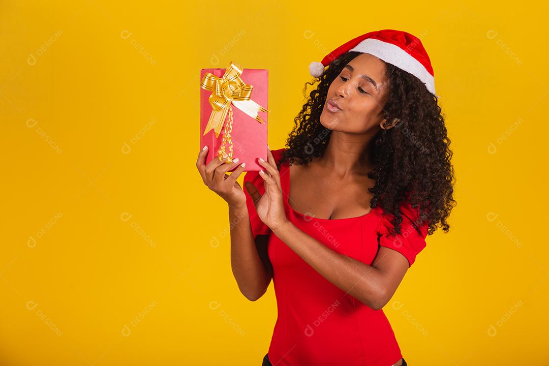 Feliz animado jovem no chapéu de Papai Noel com caixa de presente.