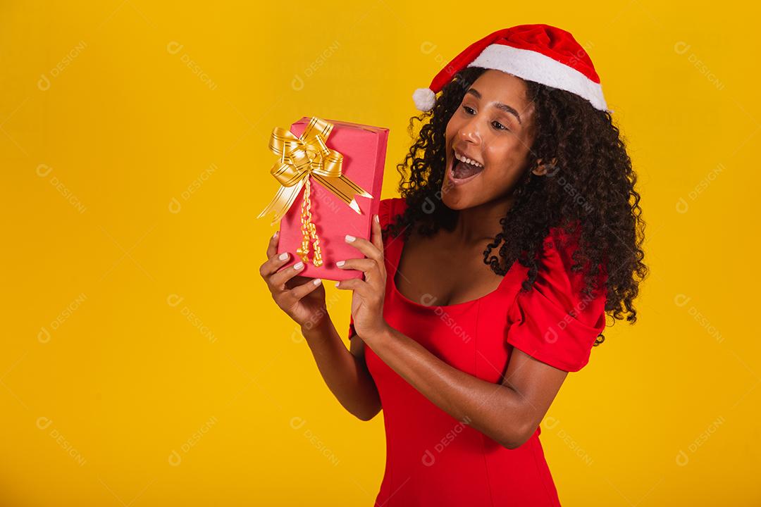 Feliz animado jovem no chapéu de Papai Noel com caixa de presente.