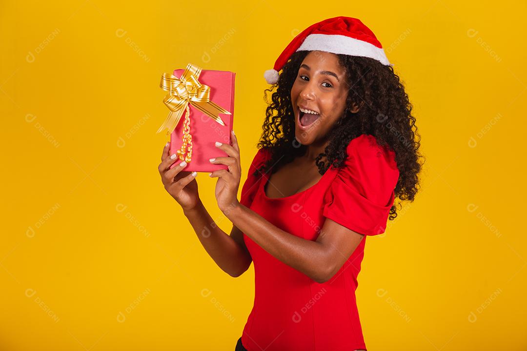 Feliz animado jovem no chapéu de Papai Noel com caixa de presente.