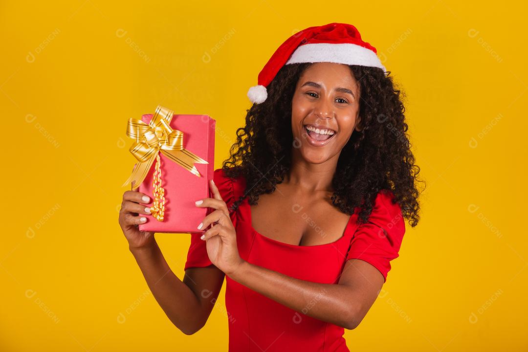 Feliz animado jovem no chapéu de Papai Noel com caixa de presente.