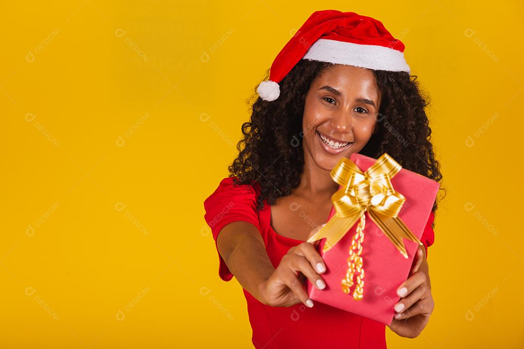 Feliz animado jovem no chapéu de Papai Noel com caixa de presente.