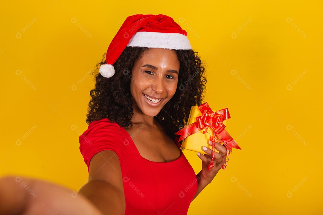 Mulher com chapéu de Papai Noel e tirar selfie com caixa de presente
