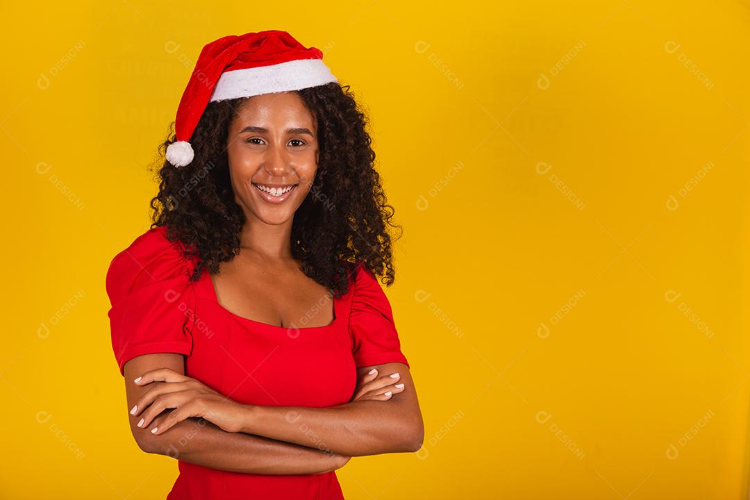 Linda mulher negra afro com cabelo encaracolado em fundo amarelo no chapéu de Papai Noel
