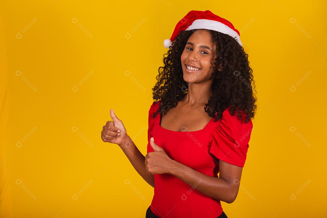 linda mulher afro em gratidão por entregar no coração com chapéu de Papai Noel
