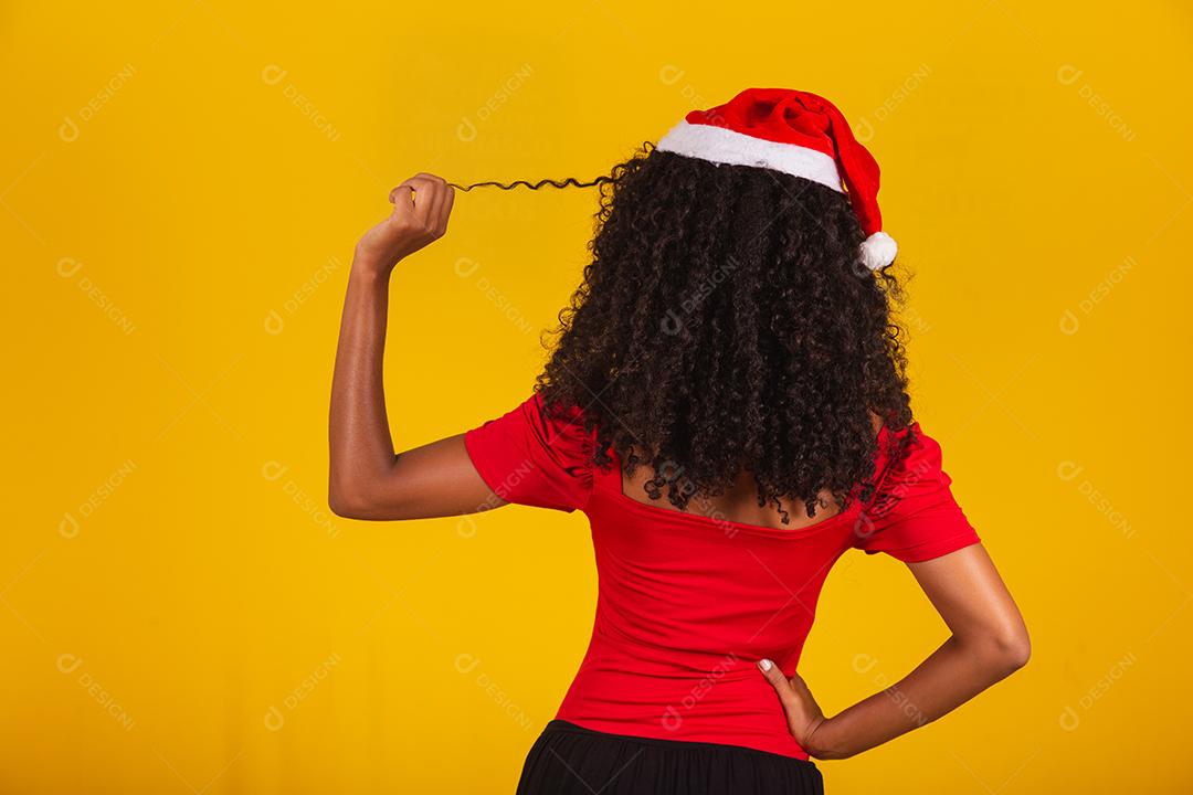 menina bonita e alegre com chapéu de Papai Noel sorrindo para a câmera