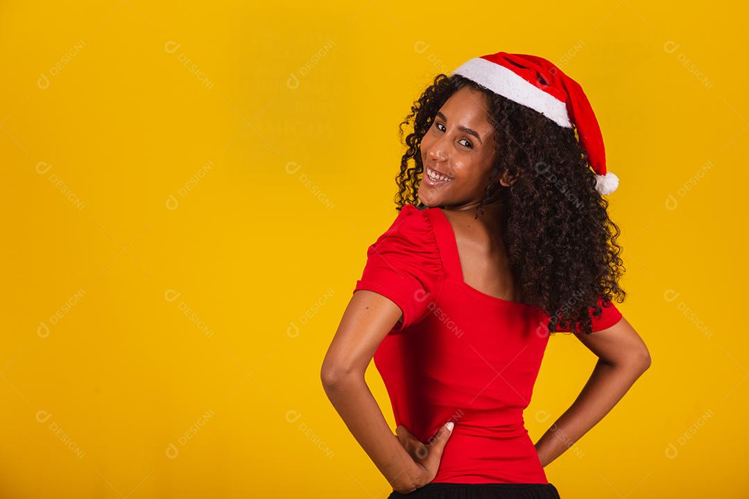 menina bonita e alegre com chapéu de Papai Noel sorrindo para a câmera