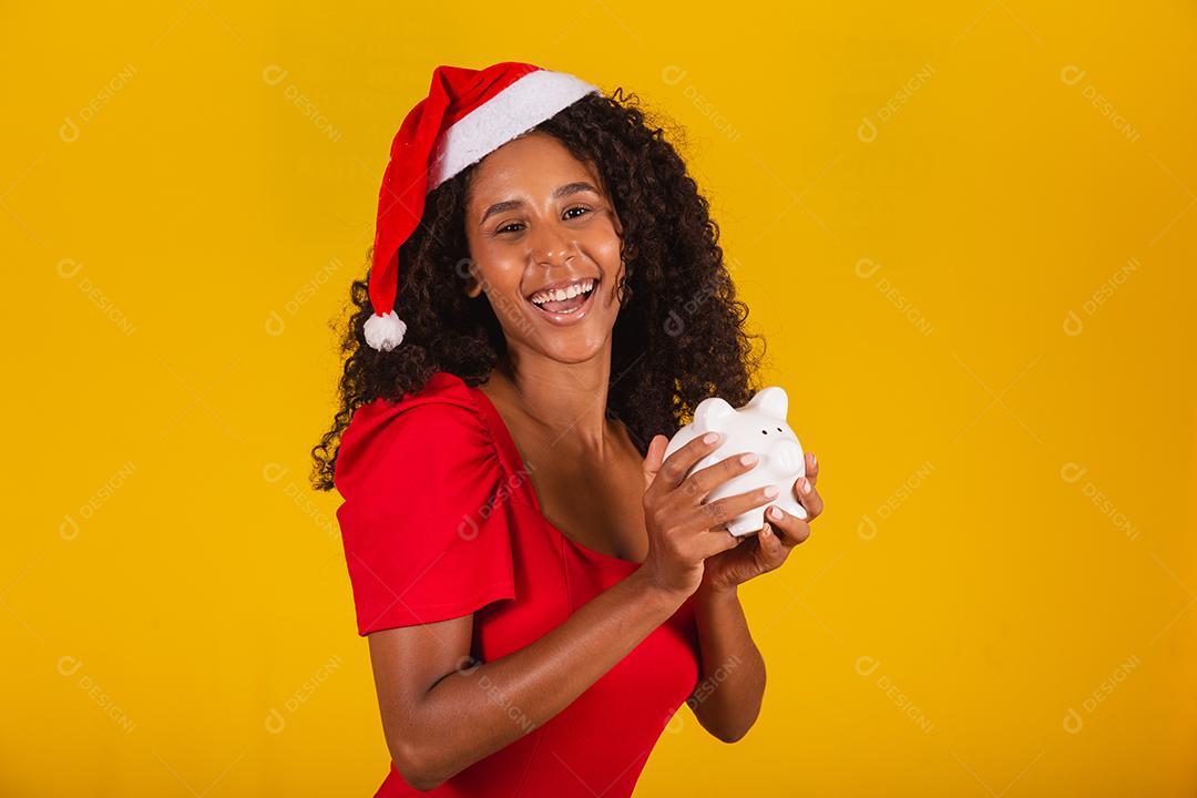 Mulher jovem e bonita pegando as economias de um cofrinho para comprar os presentes de natal