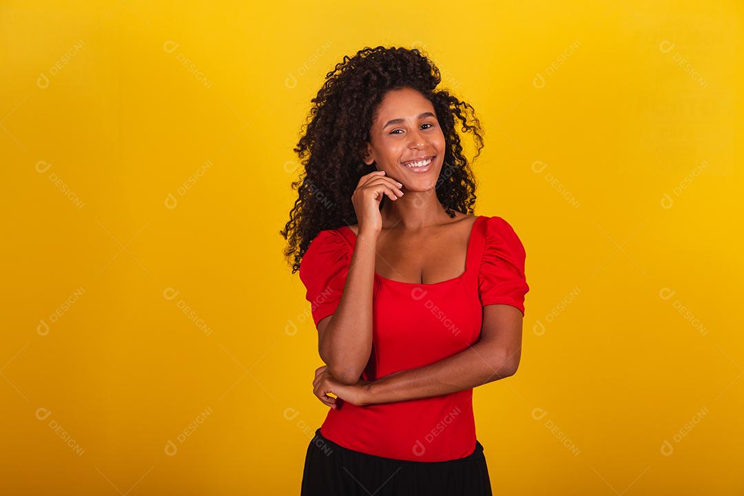 retrato de mulher negra de raça mista com grande cabelo afro, cabelo encaracolado em fundo amarelo.