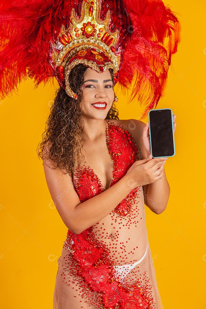 Mulher afro brasileira posando em traje de samba sobre fundo amarelo com espaço livre. Traje brasileiro de samba vestido.