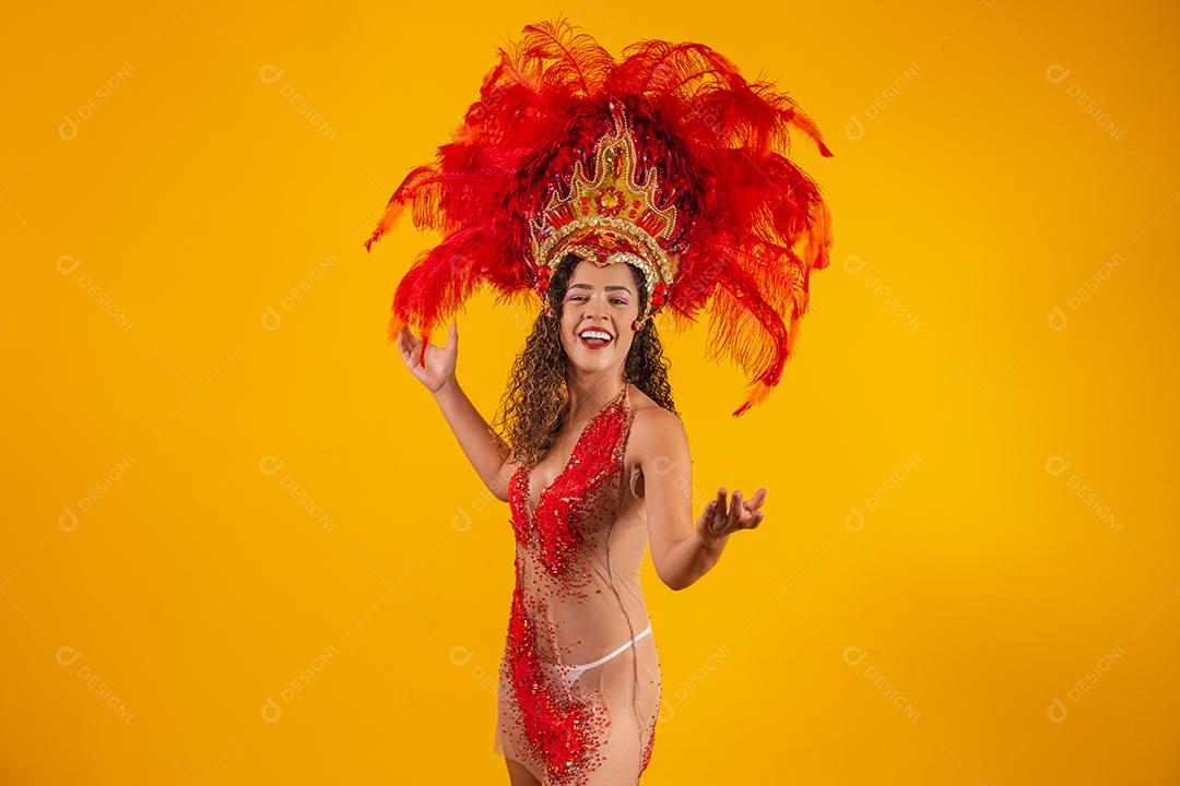 Mulher afro brasileira posando em traje de samba sobre fundo amarelo com espaço livre
