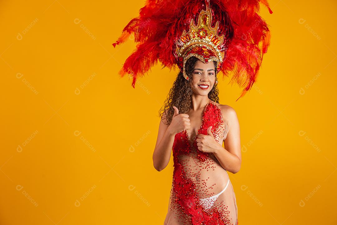 Linda dançarina está de pé com o polegar para cima fazendo sinal de ok ou positivo. Ela está vestindo uma fantasia